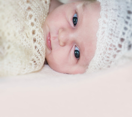Three weeks old baby girl wearing a crocheted hat