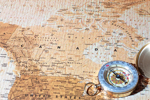Compass on a map pointing at Canada, planning a travel destination
