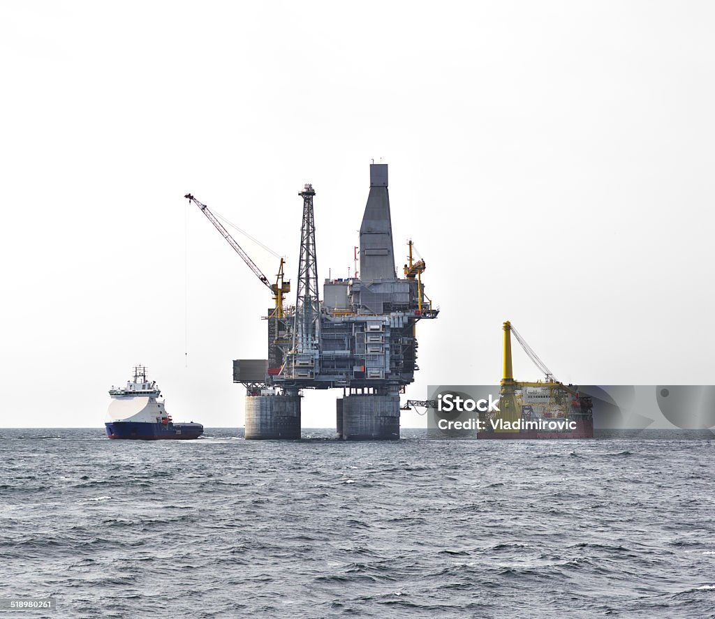 Sea ship oil rig Oil rig platform and support vessel on offshore area, cloudy gray white sky background. Photomerge Above Stock Photo