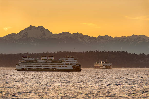 Commuters and tourists travel from the Olympic peninsula to downtown Seattle via ferry boats during a lovely springtime sunset.