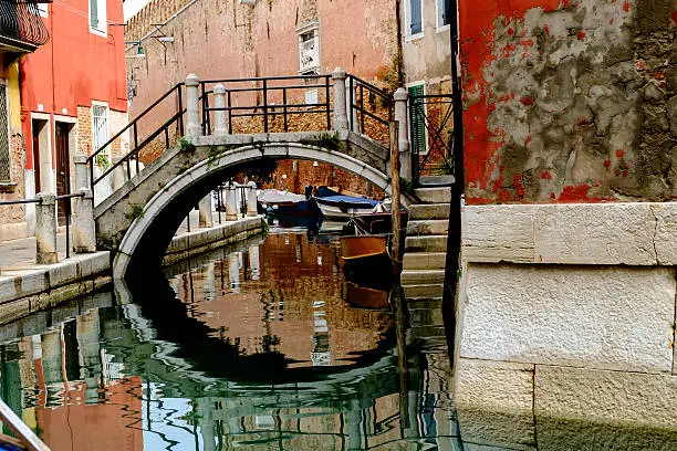 Bridge over canal in Venice with pastel colours and peeling plaster