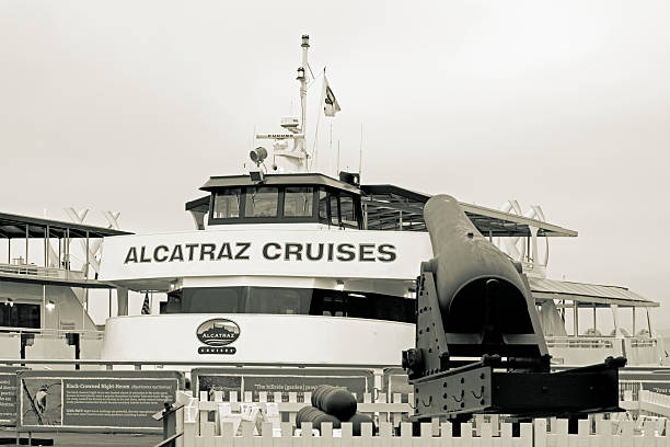 San Francisco, USA - April 14, 2014: Alcatraz cruise ship moored ready for tourist trips around San Francisco Bay.  In the foreground is an old cannon.