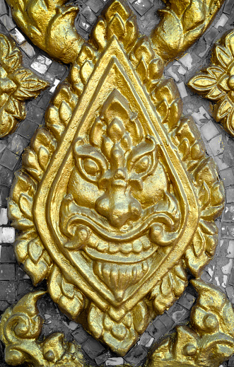 Golden giant face sculpter at Thai temple wall
