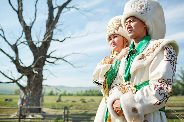 Couple in traditional dress, on background epic ancient tree at stock photo