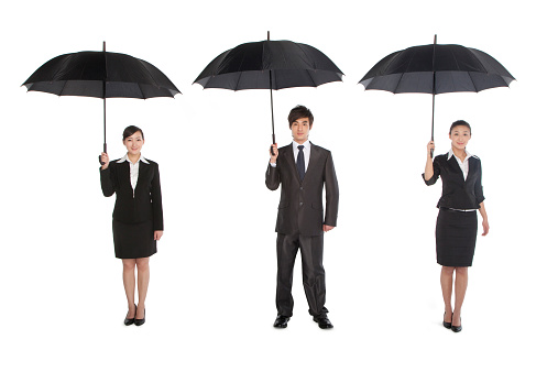 three business people holding umbrella