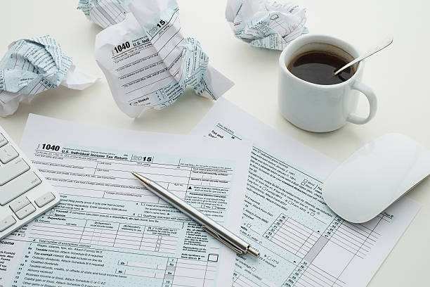 Troubles with filling 1040 US tax form The Table with Keyboard, Pen, Coffee Cup and 1040 tax form IRS Headquarters Building stock pictures, royalty-free photos & images