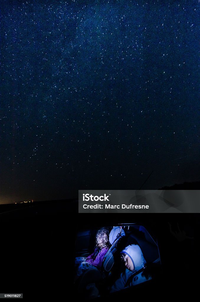 Sleeping under stars Two kids sleeping in a car with the stars and milky way above them Sleeping Stock Photo