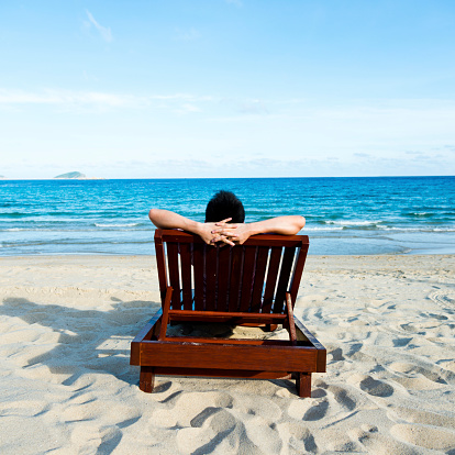 woman relaxing in a chair, enjoying the beach.