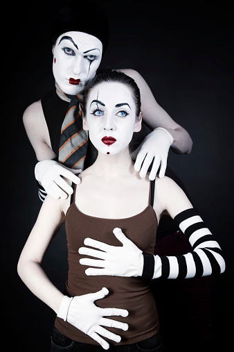 mime man tempts woman on a black background