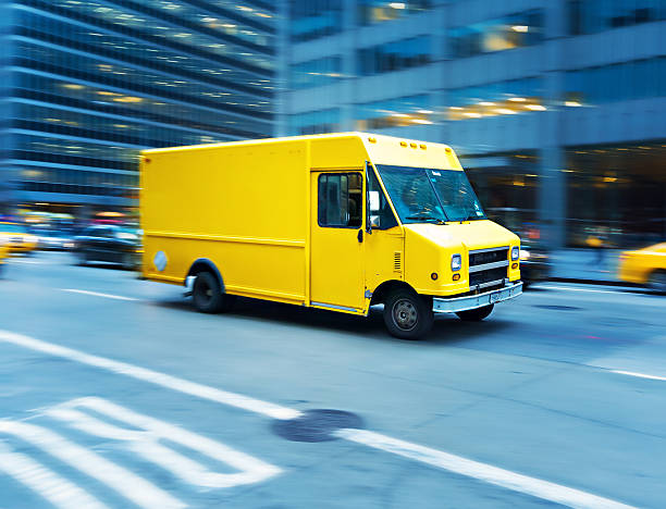 Yellow delivery truck in Manhattan Yellow delivery truck speeding in New York - motion blur, panning technique delivery van stock pictures, royalty-free photos & images