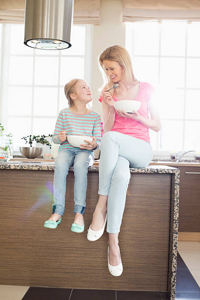 istock Mother and daughter looking at each other while having breakfast 519030271