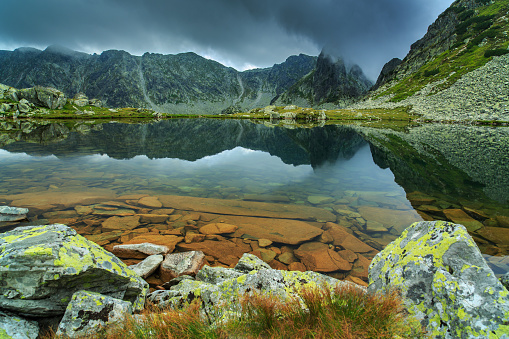 Beautiful mountain scenery in the Alps in summer, with glacier lake and storm clouds