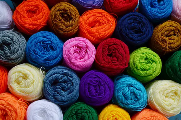 Blurry background of colorful yarn wool for knitting. View from above of colorful yarn wool for knitting.