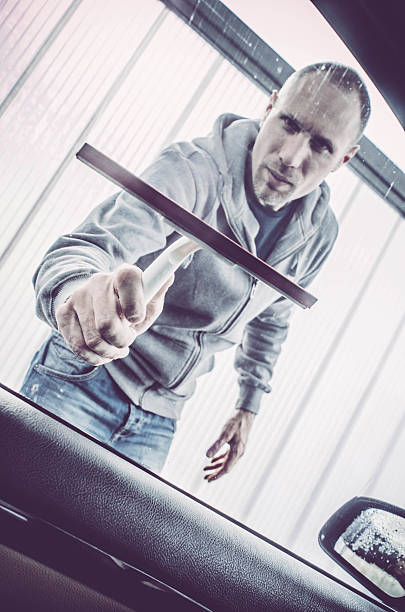 istock Man washing his car - drying windows 519049636