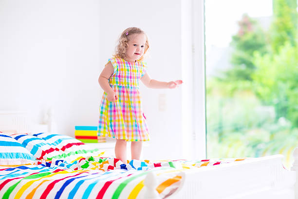 istock Little sweet girl jumping on a bed 519049835
