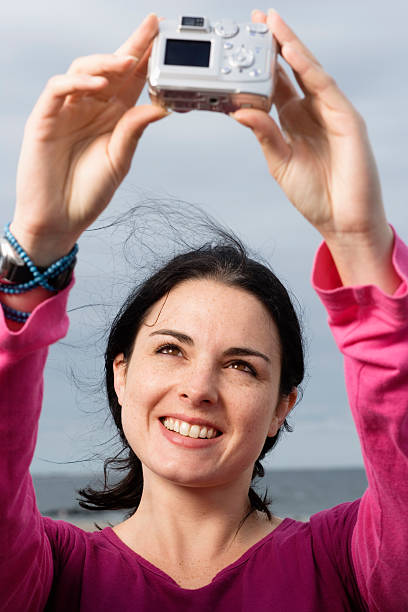 istock Young woman taking picture, smiling, close-up 519049855