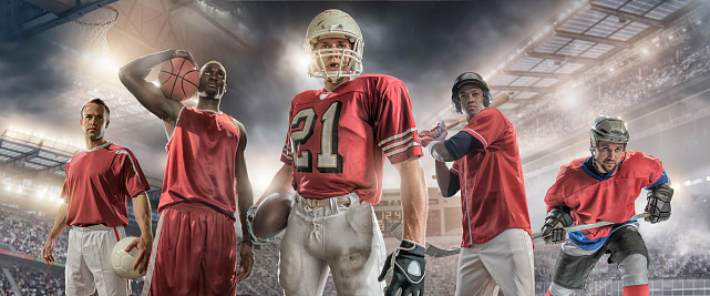 Composite portrait image of five male sporting athletes – soccer player holding football, basketball player holding basketball, American football player holding ball, baseball player holding bat and ice hockey player holding stick. Backgrounds are generic floodlit stadiums and arenas appropriate to each sport. All players are wearing generic unbranded sports strip. 