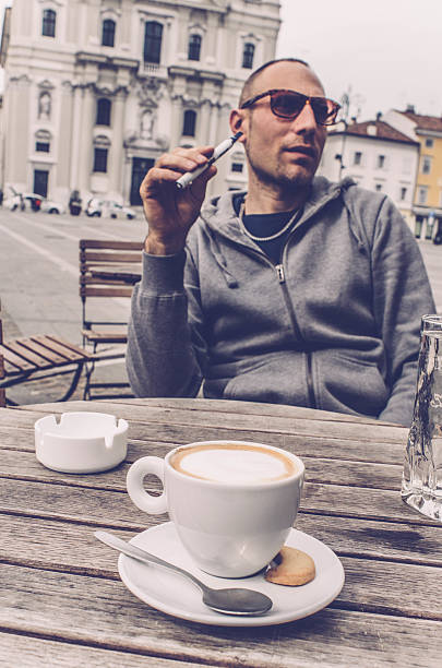 istock Man using electronic cigarette and drinking coffee, bar in Italy 519051072