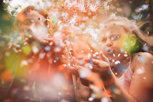 цветной бумаги конфетти проносимой ветром в камеру, детей - celebration confetti party summer стоковые фото и изображения