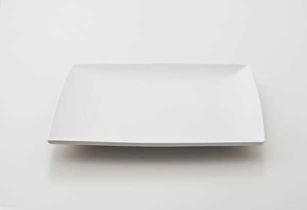 Single square porcelain plate on white background stock photo