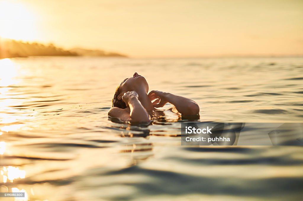 Cuidado del cuerpo. Mujer disfrutando al mar, al atardecer. Estilo de vida saludable. Verano - Foto de stock de Mar libre de derechos