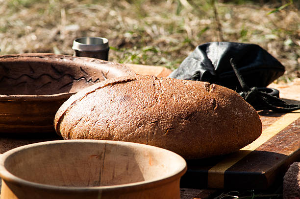 a loaf of black bread with a clay mask on the ground