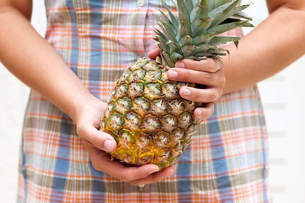 istock Woman holds pineapple in her hands 519086636