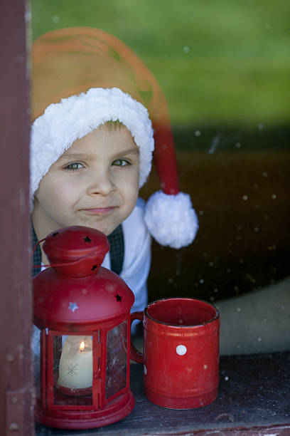 istock Adorable boy, looking through window, waiting for Santa 519089023