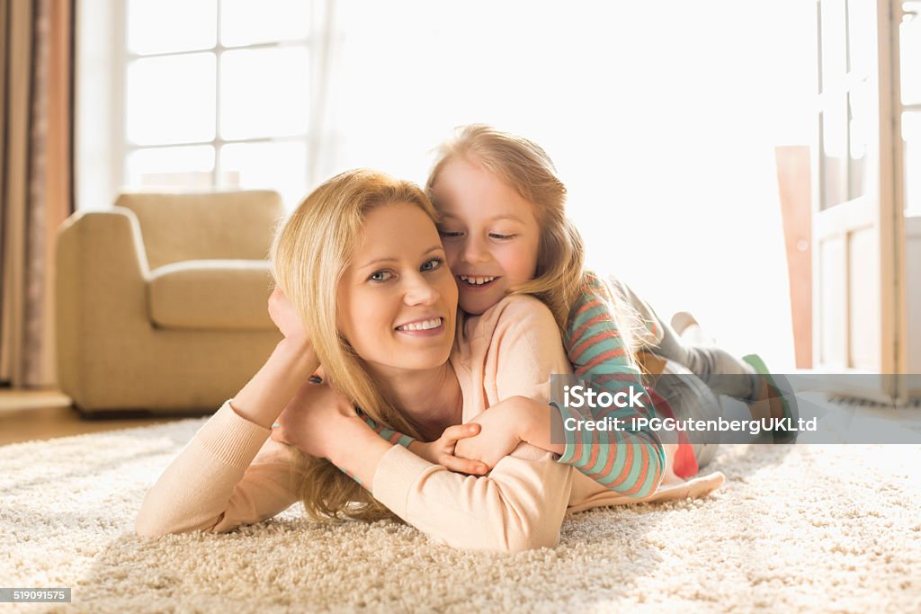 Portrait of happy mother with daughter lying on floor Portrait of happy mother with daughter lying on floor at home 30-39 Years Stock Photo