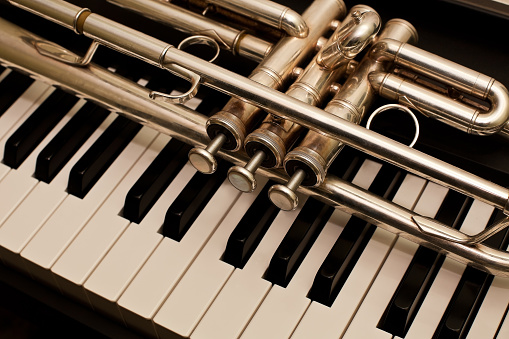 Trumpet laying on the piano keyboard closeup