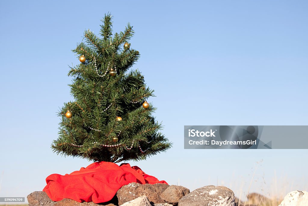 Christmas Tree Outdoors on Rocks Christmas tree with decorations in rocky hill. Artificial Stock Photo
