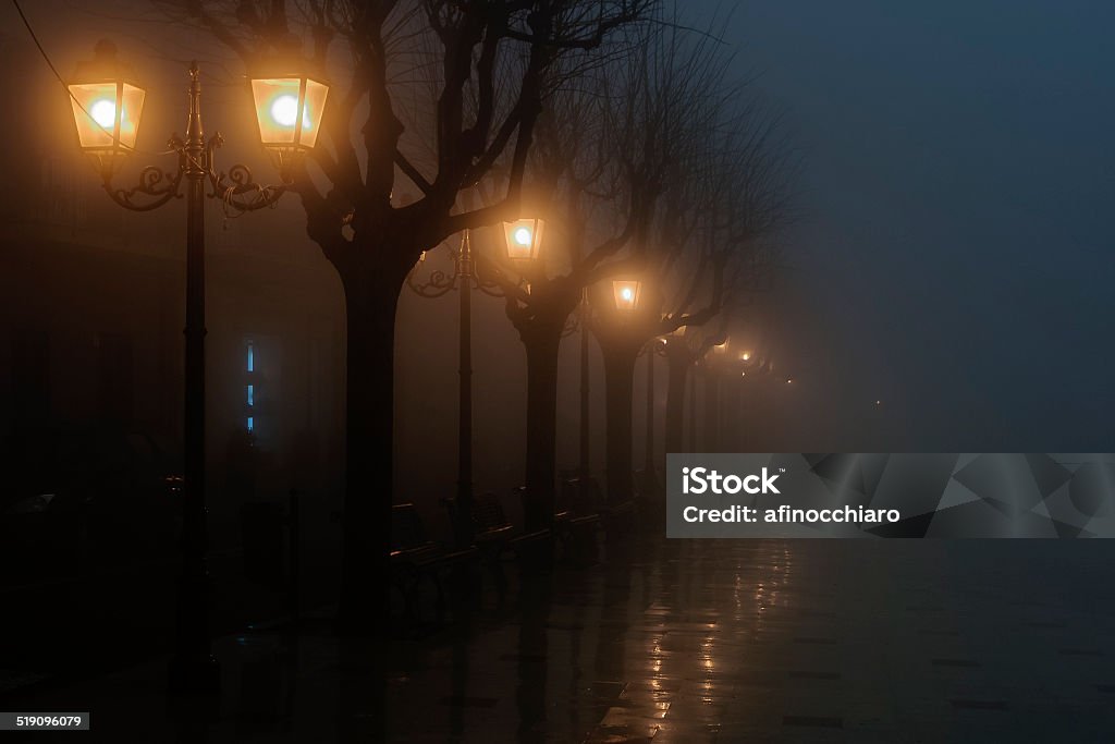 foggy night A square illuminated only by lamps in a foggy evening Black Color Stock Photo