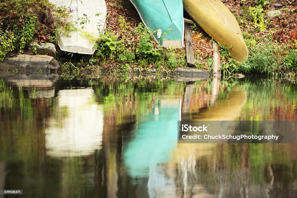 Canoe Kayak Sailboat Dinghy Shore Reflection Canoes overturned along shore with reflection.  Soft focus.  Hardyston Township, New Jersey, 2014. Camping Stock Photo