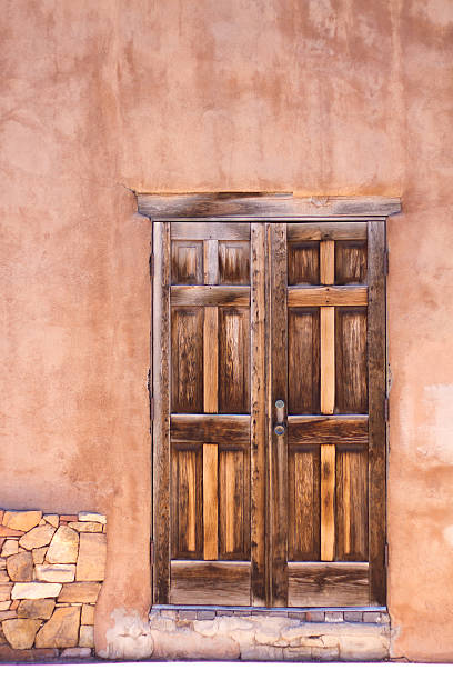 Santa Fe style: an old wooden door in a brown adobe wall.