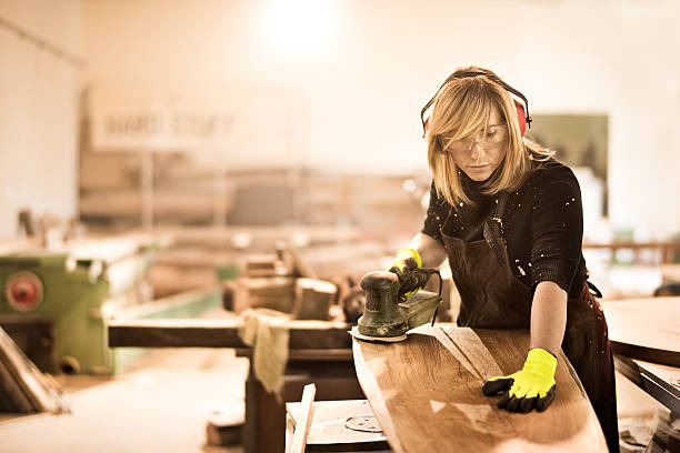 istock Blonde craftsperson power sanding wood 519122356
