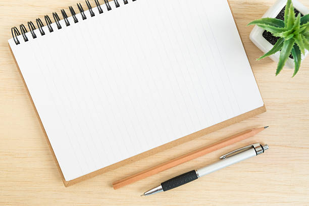 istock Top view of desk with spiral notebook on wood table 519123512