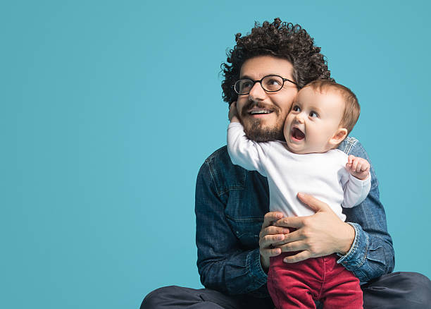 Father and daughter on blue background, Smiling portrait
