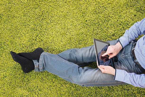 istock young man sitting on a carpet with tablet 519127478