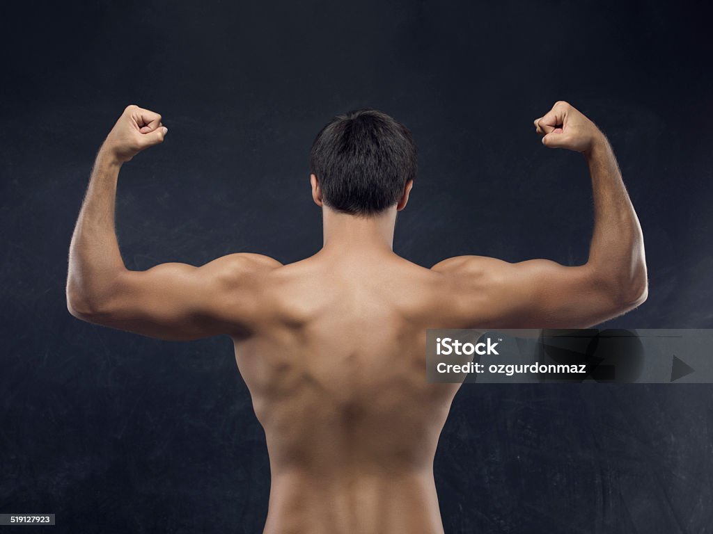 Muscular Men showing his back muscles Muscular men showing his back muscles,studio shot Adult Stock Photo