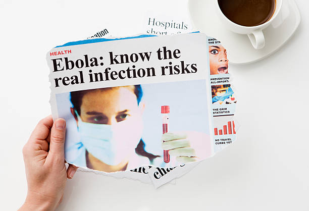 istock Hand with newspaper whose headline warns of Ebola infection risks 519128013