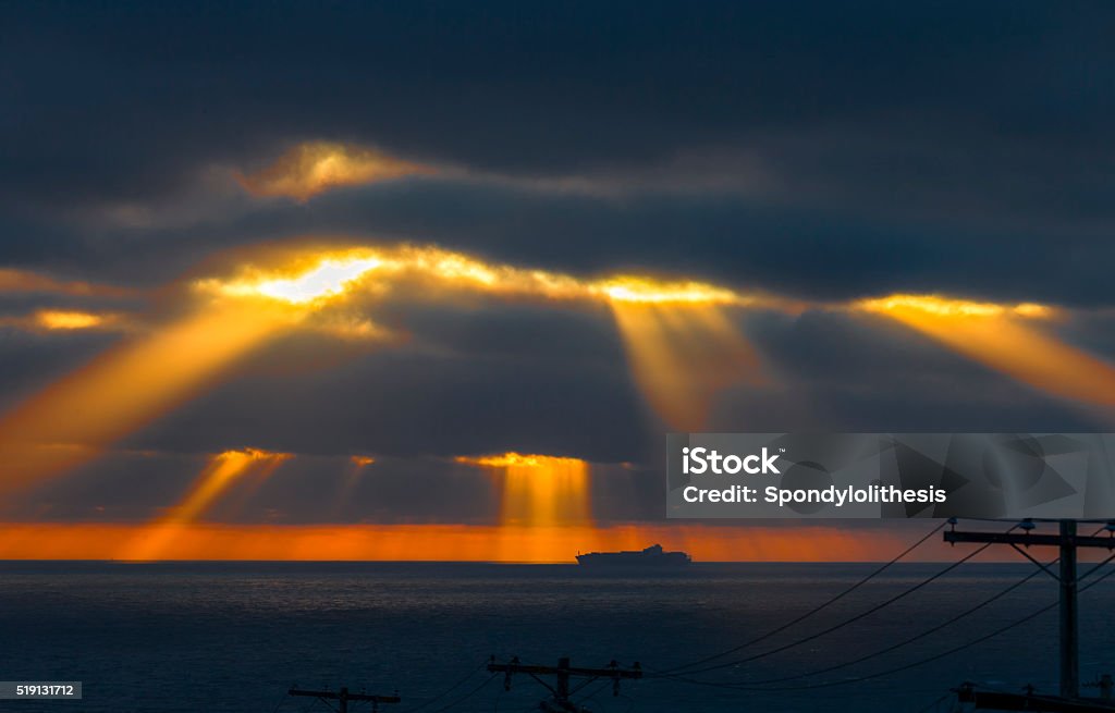 Dramatic Sunbeam at San Francisco Ocean Beach Dramatic Sunbeam at San Francisco Ocean Beach during sunset. A remote cargo boat on the background. Awe Stock Photo