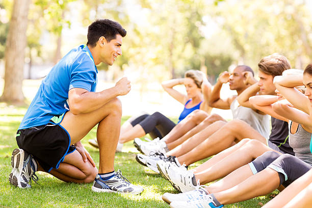 istock Fitness Instructor Motivating People In Doing Sit-Ups At Bootcamp 519132271