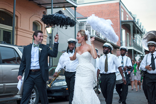 New Orleans, USA - October 10, 2014: Newly wed bride and groom parade through the streets of the French Quarter in New Orleans followed by a jazz band in celebration of their union.