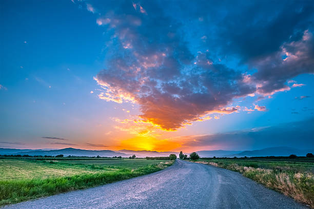 istock Road on meadow with beautiful sunset sky 519155460