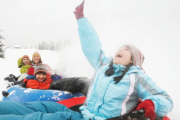 Family riding snow tubes