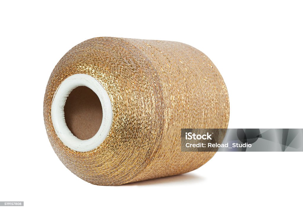 Horizontal pool of golden thread. Golden bobbin, isolated on white with a clipping path. Art And Craft Stock Photo
