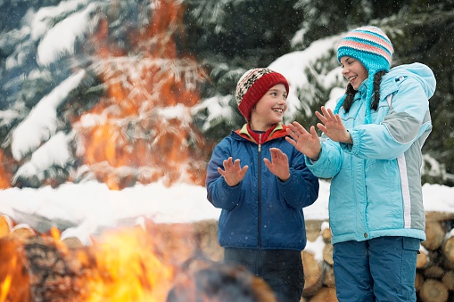 Children warming hands by a fire