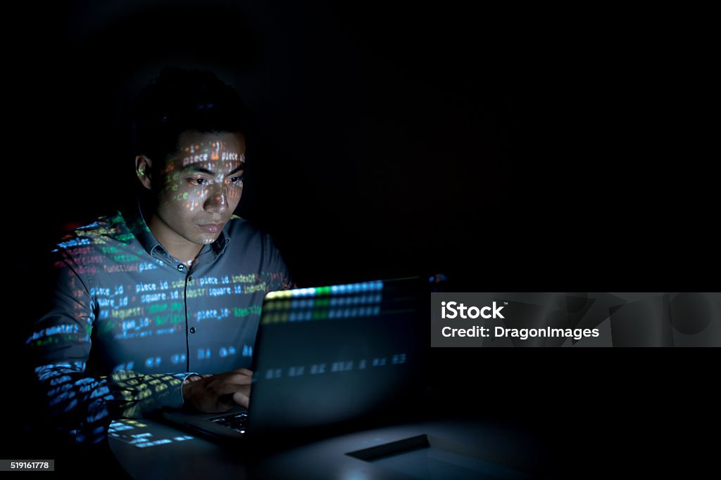 Software developer Software developer coding on his laptop at night Scientific Experiment Stock Photo