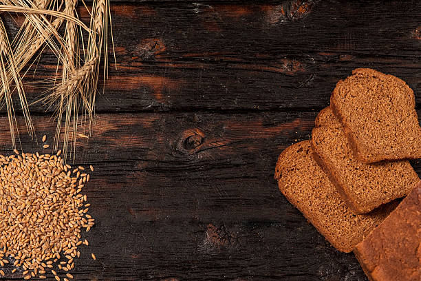 istock Spikelets of wheat and rye bread on a wooden table 519162274