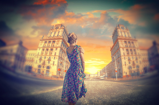 woman standing in dress. Two towers on Railway station square City Gates Minsk Belarus